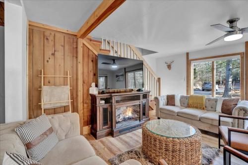 a living room with a couch and a fireplace at Hot Tub + Prime Location Chalet in Pocono Summit