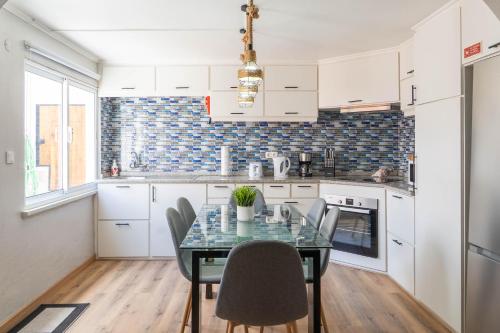 a kitchen with a dining room table and chairs at Green Mountain in Mosteiros