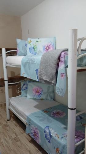 a bunk bed with blue and white sheets and pillows at CANTINHO SÃO PEDRO in Maceió