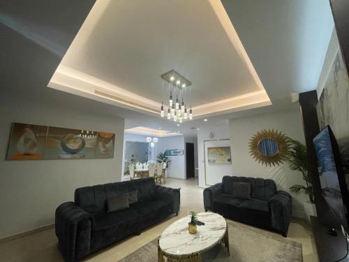 a living room with two black couches and a table at Eko Atlantic Units Of 2Bedrooms & 3Bedrooms Apartments, Lagos in Inupa