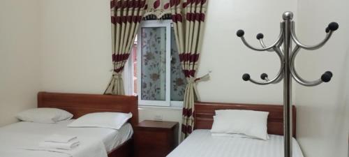 une chambre avec deux lits et un miroir dans l'établissement Hotel Phương Anh bá thiện 2 vĩnh phúc, à Trung Mậu