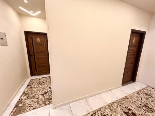 two doors in a room with marble floors at New Jazal pyramids view in Cairo