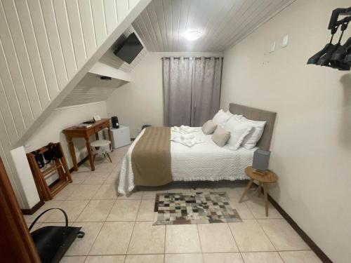 a bedroom with a bed in a room with a staircase at Pousada Flor de Lua Monte Verde in Monte Verde