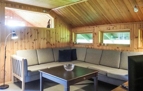 a living room with a couch and a table at Holiday Home Strandtoften Kirke Hyllinge Iii in Sæby