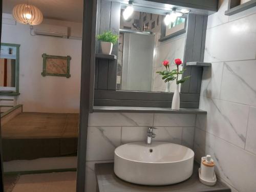 une salle de bain avec un lavabo et un miroir dans l'établissement Guest House Green Corner Supetarska Draga - Double Room With Balcony and Sea View, à Rab