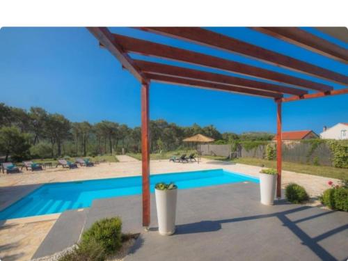 un pabellón con piscina frente a una casa en Villa P - Holiday Home, en Šibenik
