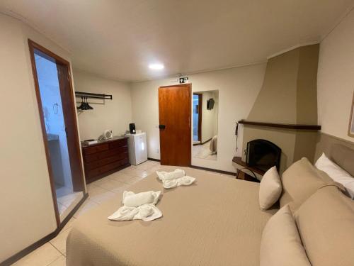 a bedroom with a bed with towels on it at Pousada Flor de Lua Monte Verde in Monte Verde