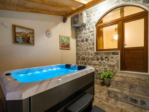 a large blue tub in a room with a stone wall at Apartment Fortuno - One Bedroom Apartment with Terrace and Sea View in Mlini