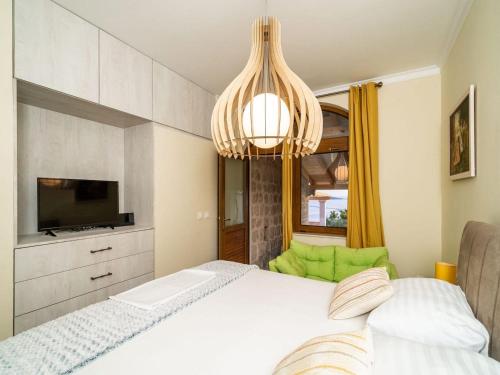 a bedroom with a white bed and a chandelier at Apartment Fortuno - One Bedroom Apartment with Terrace and Sea View in Mlini