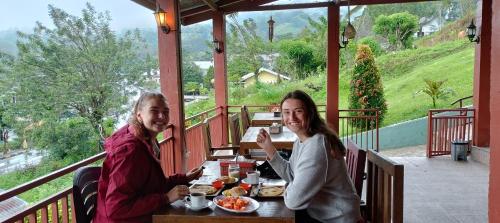 a man and woman sitting at a table eating food at Moon view Bungalow's in Kelimutu