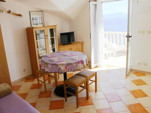 a room with a table and chairs and a balcony at Apartments Pansion Franka 3 - Apartment 11 in Brist