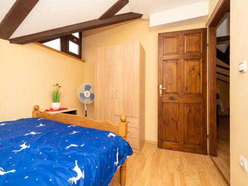 a bedroom with a blue bed and a wooden door at Holiday home with hot tube and 1 room in Donja Stubica