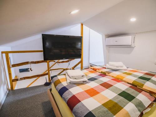 a bedroom with a bed and a flat screen tv at Sleek and Stylish Umag Apartments with Sea View - Comfort Two Bedroom Apartment with Terrace in Umag