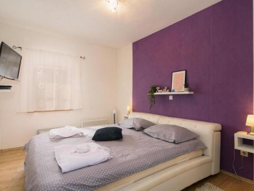 a bedroom with a bed with a purple wall at Vila Ive winter spa Podumci in Podumci