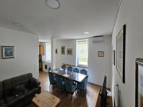 a living room with a table and blue chairs at Apartment Gracac - Two Bedroom Apartment with Terrace in Gračac