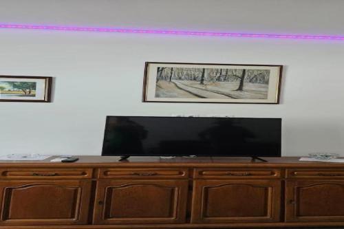 a wooden entertainment center with a flat screen television on it at Apartment Gracac - Two Bedroom Apartment with Terrace in Gračac