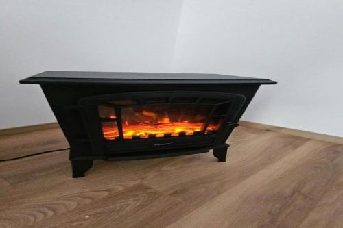 a black fireplace sitting on top of a wooden floor at Apartment Gracac - Two Bedroom Apartment with Terrace in Gračac