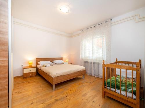 a bedroom with a bed and a crib in it at Five Bedroom Villa in Zadar
