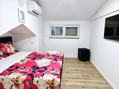 a bedroom with a bed with a red floral blanket at Villa Nika - Three Bedroom Villa with Private Pool in Lozovac