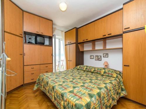 a bedroom with a bed and wooden cabinets at Three bedroom Apartment with terrace and sea view in Postira