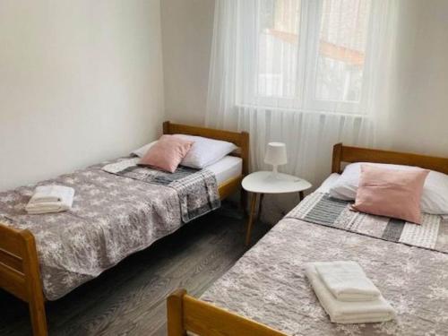 two twin beds in a room with a window at Villa Brazza - Two Bedroom Apartment 1 in Milna