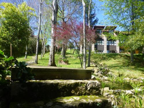 a garden with a house in the background at Hotel El Carmen in Ribadesella