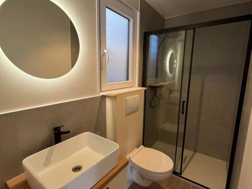 een badkamer met een wastafel, een toilet en een spiegel bij Two Bedroom Mobile Home with Terrace and Sea View in Drage