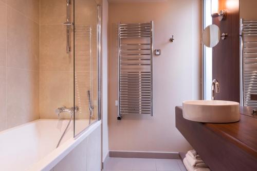 a bathroom with a sink and a shower and a tub at Hôtel La Bourdonnais by Inwood Hotels in Paris