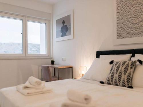 ein weißes Schlafzimmer mit einem Bett und einem Fenster in der Unterkunft Luxury Villas Bellavista - Four Bedroom Villa with Pool in Pag