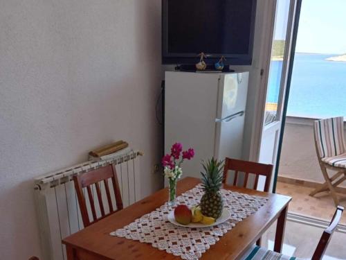 a dining room table with a pineapple and fruit on it at Apartments Julia - Triple Room Julia 4 in Martinšćica