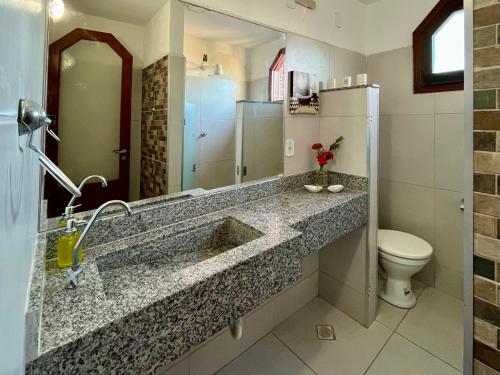 a bathroom with a sink and a toilet at Casa de Vó in Porto Seguro