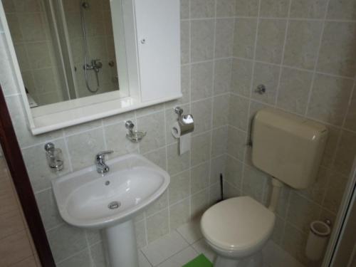 a bathroom with a sink and a toilet and a mirror at Apartments Julia - Studio Apartment Julia 3 in Martinšćica