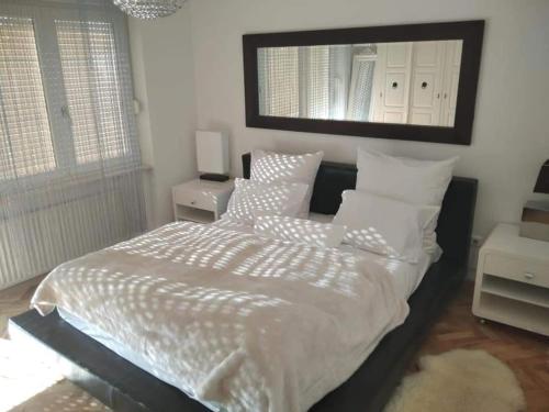 a bedroom with a bed with white sheets and a mirror at Holiday Home Dugo Selo M&A - Five Bedroom Holiday Home with Terrace in Zagreb