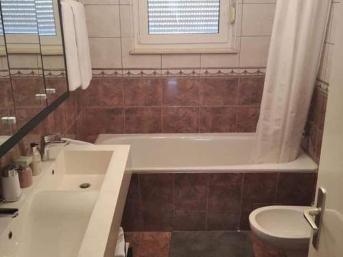 a bathroom with a tub and a toilet and a sink at Holiday Home Dugo Selo M&A - Five Bedroom Holiday Home with Terrace in Zagreb