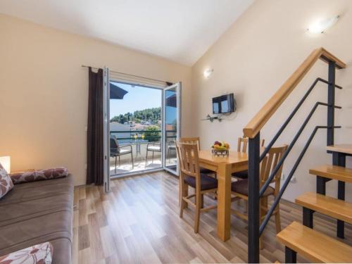 a living room with a staircase and a table with chairs at Apartments Nmn - Studio Apartment with Balcony 2 in Drvenik