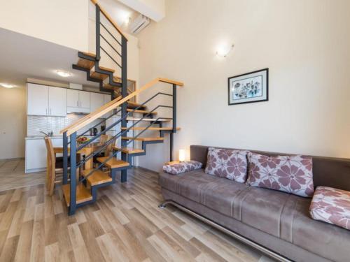 a living room with a couch and a spiral staircase at Apartments Nmn - Studio Apartment with Balcony 3 in Drvenik