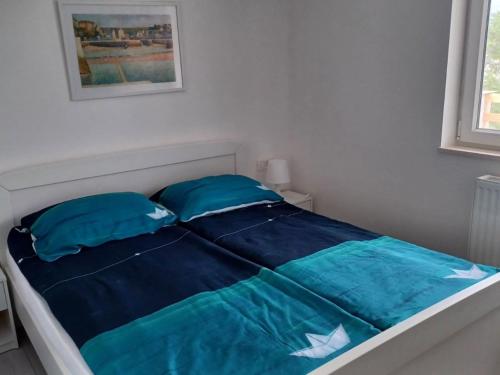 a bed with blue sheets and pillows in a bedroom at FreeMe Apartment - One Bedroom Apartment with Balcony and Sea View in Lumbarda