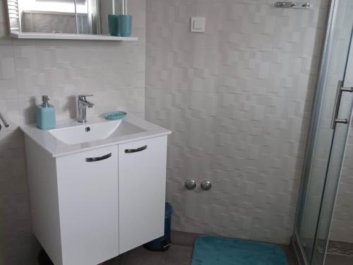 a white bathroom with a sink and a shower at FreeMe Apartment - One Bedroom Apartment with Balcony and Sea View in Lumbarda