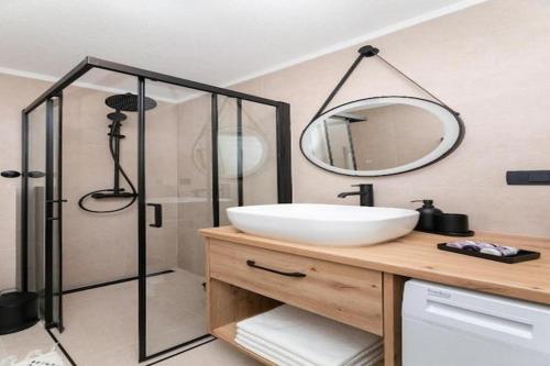 ein Badezimmer mit Waschbecken und Dusche mit Spiegel in der Unterkunft Villa ADRIANA - Two bedroom Villa with swimming pool in Nerežišće