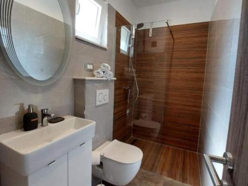 a bathroom with a toilet and a sink and a shower at Villa Tamaris - Two Bedroom Holiday Home with Terrace and Swimming pool in Mali Drvenik