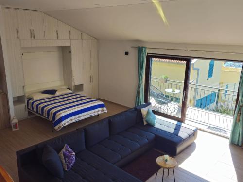 a living room with a blue couch and a bed at Holiday Home Sunrise - Three Bedroom Holiday Home in Omiš
