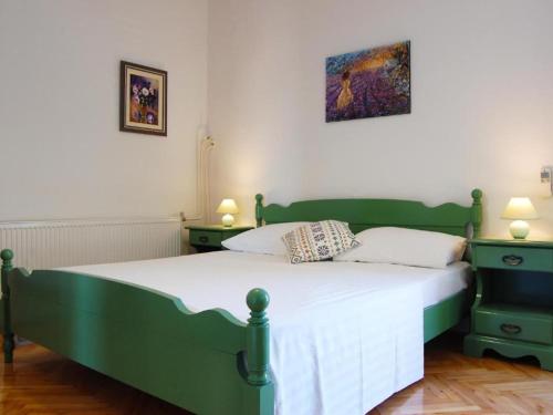 a bedroom with a green bed with two night stands at Apartment Juri i Kor ula - One Bedroom Apartment with Terrace in Korčula