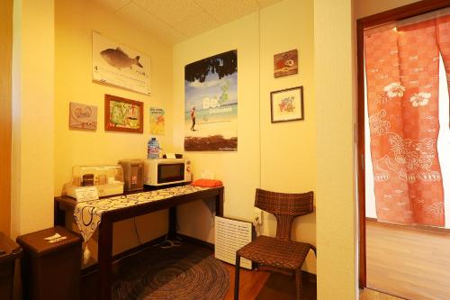 a room with a desk with a microwave and a computer at 民宿さざんか in Okinawa City