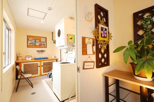 a kitchen with a white refrigerator and a table at 民宿さざんか in Okinawa City