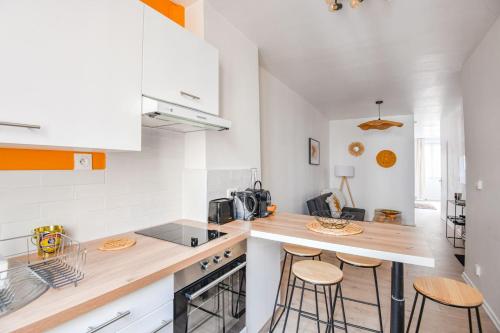 une cuisine avec des armoires blanches et des tabourets de bar dans l'établissement Le Solea - Bel appart 1 ch proche Vieux-Port, à Marseille