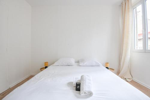 - un lit blanc avec un appareil photo et des serviettes dans l'établissement Le Solea - Bel appart 1 ch proche Vieux-Port, à Marseille