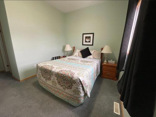 a bedroom with a large bed and two lamps at NEWCASTLE COUNTRY INN in Drumheller