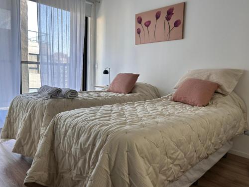 Dos camas una al lado de la otra en un dormitorio. en Excelente Apartamento en calle Moldes, en Buenos Aires