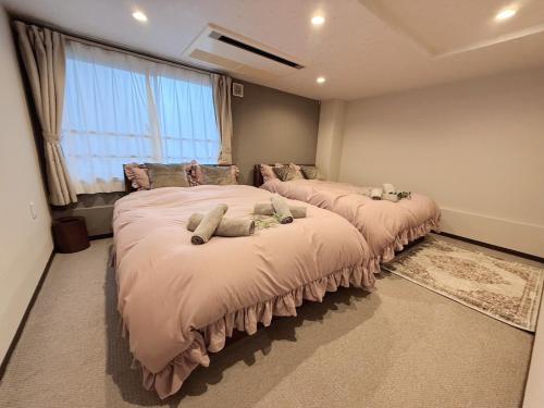 1 dormitorio con 2 camas con animales de peluche en Hotel GRACIAS KOBE, en Kobe