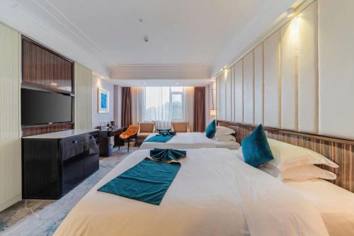 a hotel room with two beds and a television at 清远市迎宾馆 in Qingyuan